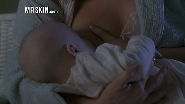 En smal sak ligger på ryggen på massagebordet och ler