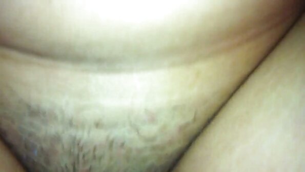 En kvinna med en fast röv ligger på sängen och skakar sina stora bröst