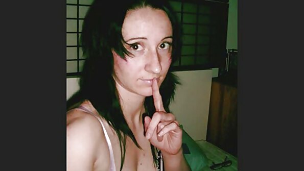 En blondin är ensam i soffan och leker intensivt med sig själv