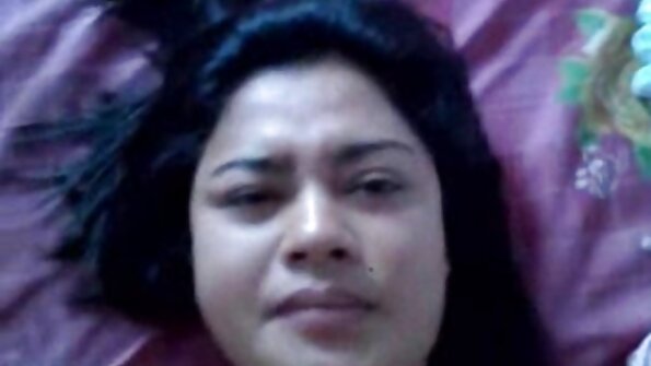 En kvinna med sönderdelade jeans knullas i sängen på ryggen