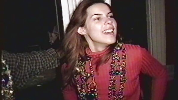 En blondin som har stora bröst placerar ansiktet ovanpå en tunga